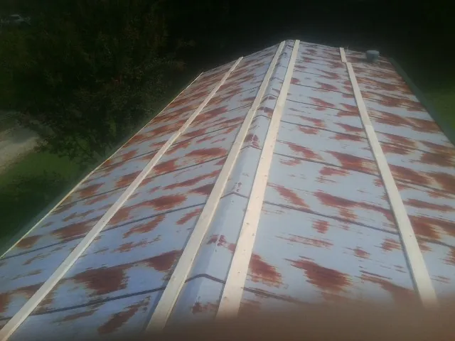 Rusted metal roof panels with new wood purlins before replacement — Storm Damage Roof Repair in East Alton by Roofing Brothers