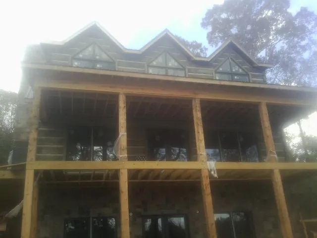 Dormers and porch framing on a large log home under construction — Roof Coating work by our crew in East Alton