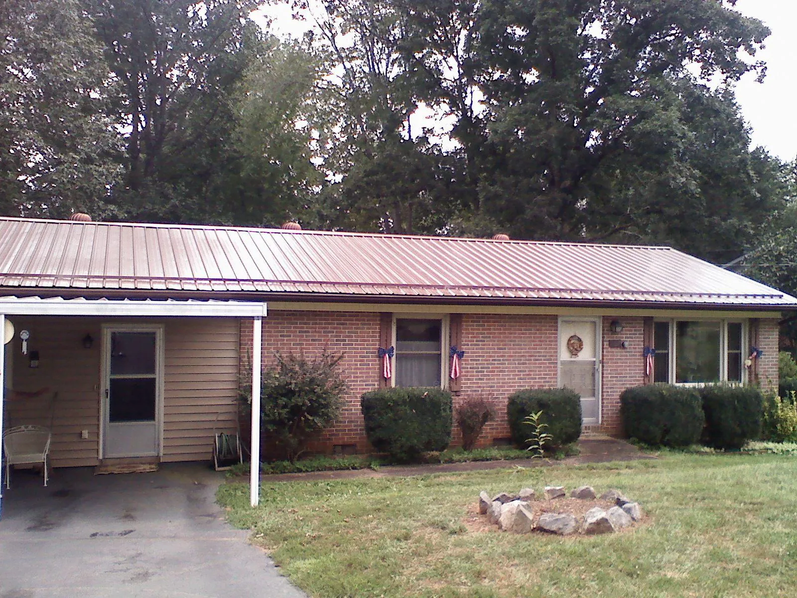Bronze metal roof and carport on a brick ranch home — Roof Repair work by our crew in East Alton