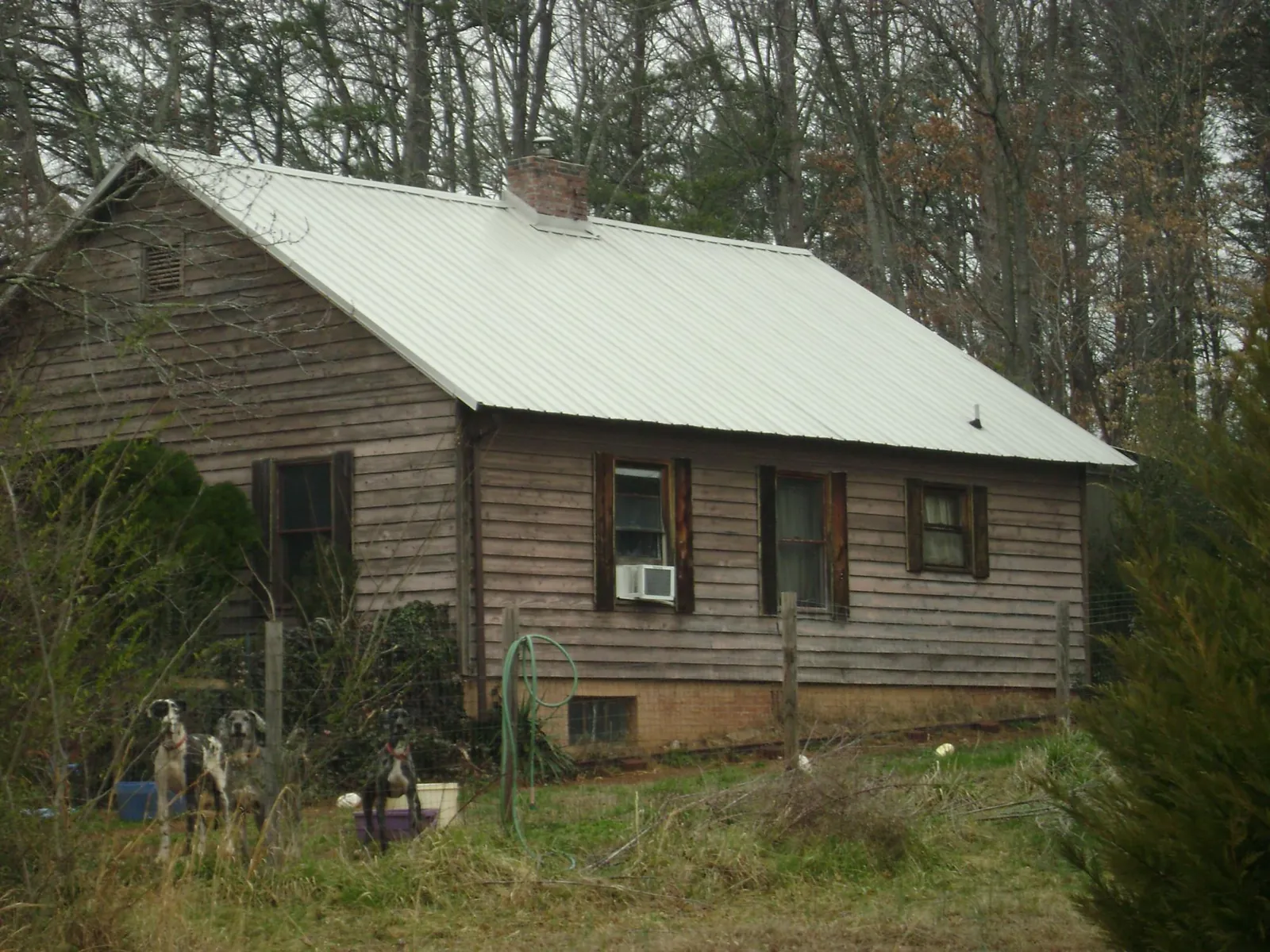 White metal roof on an old wood sided farmhouse, from a Metal Roof Installation job in East Alton
